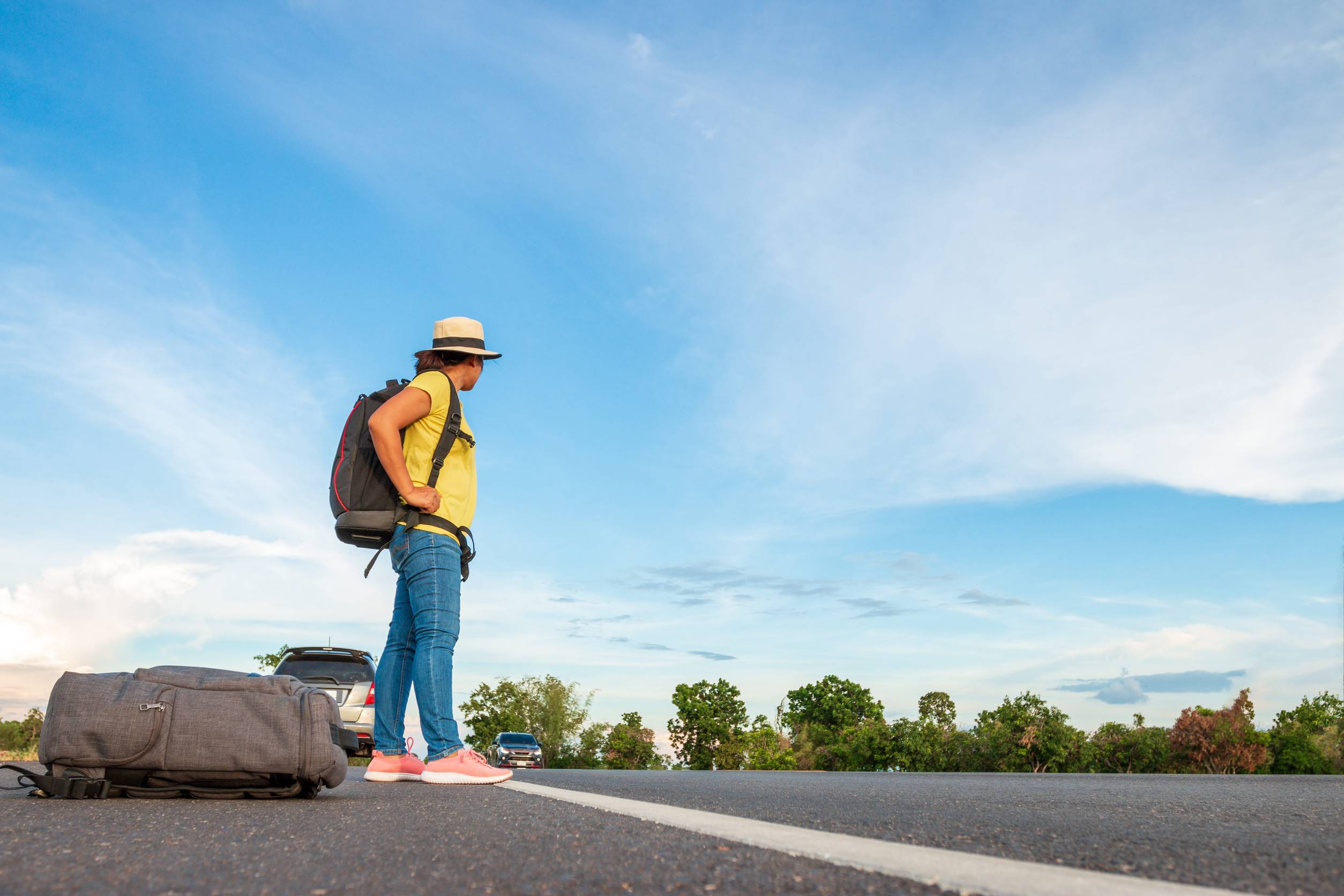 Female Travellers Waiting For Cars To Stop And Help
